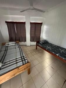 a room with two beds and a ceiling at YaNuYaNu Appartment Nabua in Suva