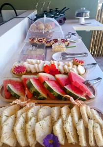 a table topped with slices of watermelon and other foods at Arraia Suítes Pousada in Pipa
