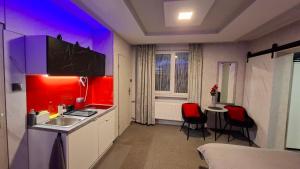 a kitchen with a sink and a table with chairs at Hortensja 309 in Koszalin