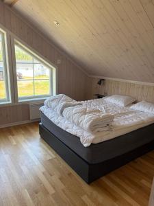 a large bed in a room with two windows at Fjällstuga Vemdalsskalet in Vemdalen
