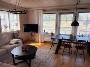 a living room with a table and a dining room at Fjällstuga Vemdalsskalet in Vemdalen