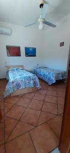 ein Schlafzimmer mit zwei Betten und einem Deckenventilator in der Unterkunft Attico 5 in Ustica