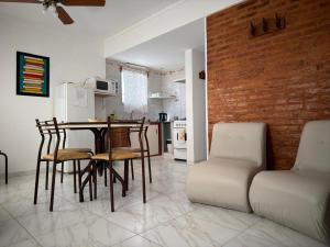 a kitchen with a table and chairs and a brick wall at Caleta Austral - dptos in Las Grutas