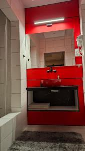 a bathroom with a red sink and a mirror at Hortensja 309 in Koszalin