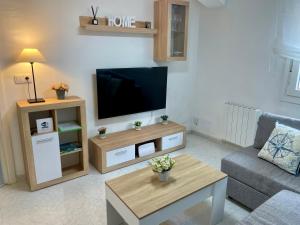 a living room with a flat screen tv on a wall at El Orbayín de Llastres in Lastres