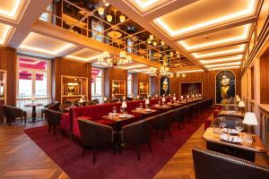 a restaurant with long tables and red chairs at 1904 Benfica Hotel FLH Hotels in Lisbon