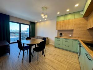 a kitchen with a table and chairs in a room at Apartament Kwiatowa in Tychy
