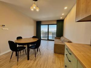 a kitchen and living room with a table and chairs at Apartament Kwiatowa in Tychy
