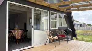 a screened in porch with chairs and a table at Awhina's Lodge in Ohakune