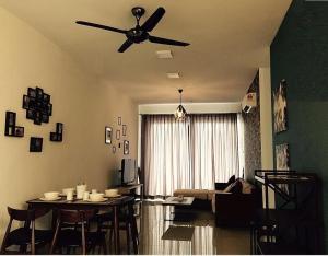 een woonkamer met een plafondventilator en een tafel bij The Majestic condo Ipoh in Ipoh