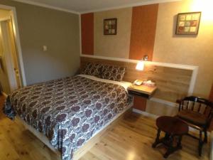 a bedroom with a bed and a table and a chair at Galaxy Motel in St. Paul
