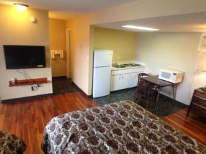 a hotel room with a bed and a desk and a kitchen at Galaxy Motel in St. Paul