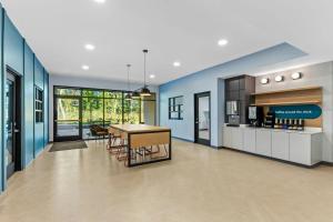 a kitchen and dining room with blue walls and a table at StudioRes by Marriott Jacksonville Orange Park in Orange Park