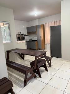 a kitchen with a wooden table and benches in a room at Apartamento Sabrina in Curitiba