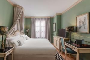 a bedroom with a bed and a desk with a computer at Eugenia de Montijo, Autograph Collection in Toledo +34 photos
