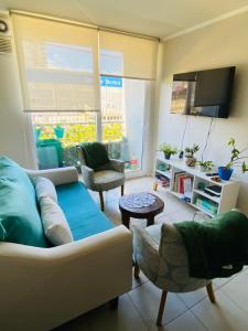 a living room with a couch and chairs and a tv at Acogedor Apartamento 2D1B Edificio Aldunate in Temuco
