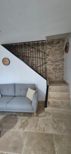 a living room with a couch and a staircase at Le Donjon du Chateau in Tournissan