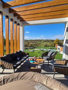 a patio with a couch and chairs and a table at Casa Toleni in Ba°evac
