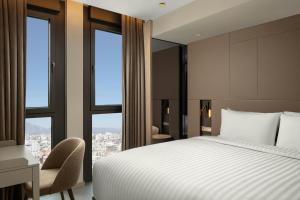 a bedroom with a bed and a desk and windows at Residence Inn by Marriott Antalya in Antalya +39 photos