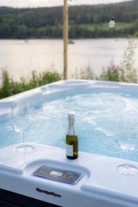 a bottle of wine and two wine glasses in a hot tub at Gnist Retreat in Sørumsand