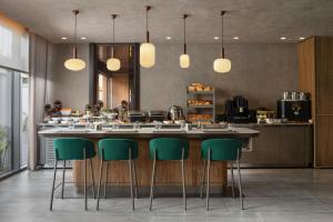 a kitchen with a counter with green bar stools at Residence Inn by Marriott Antalya in Antalya