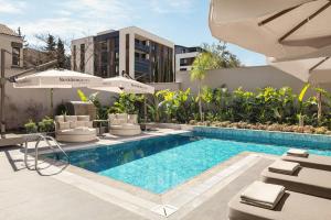 a pool with chairs and umbrellas next to a building at Residence Inn by Marriott Antalya in Antalya
