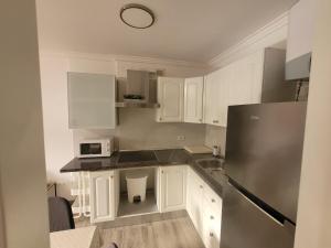 a kitchen with white cabinets and a stainless steel refrigerator at Lavilla1XO in Valverde