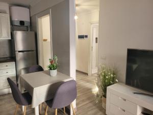a kitchen with a table with purple chairs and a television at Lavilla1XO in Valverde