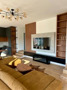 a living room with a couch and a large tv at Casa Toleni in Ba°evac