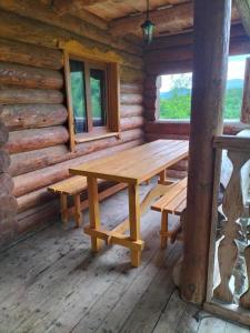 a wooden table and benches in a log cabin at Садиба для відпочинку in Vyshka