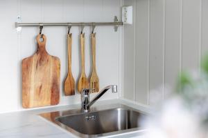 a kitchen sink with wooden utensils on the wall at Gnist Retreat in Sørumsand
