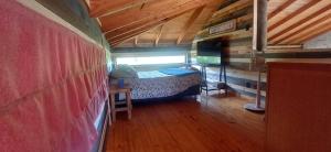 a small room with a bed in a tiny house at Hostal Arboretum cafeteria & jardin in Hijuelas