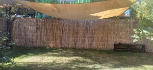 a wooden fence with a bench in a backyard at Hostal Arboretum cafeteria & jardin in Hijuelas +6 photos