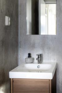 a bathroom with a white sink and a mirror at Gnist Retreat in Sørumsand