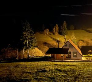 a small house in a field at night at Casa Ionuț și Sofia in Podu Dîmboviţei