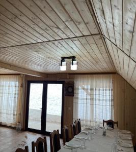 a dining room with a table and chairs and a window at Casa Ionuț și Sofia in Podu Dîmboviţei