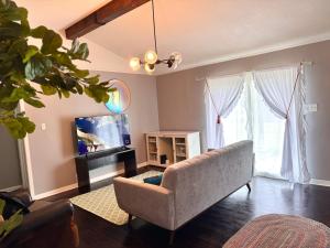 a living room with a couch and a flat screen tv at MODERN LUX 3BR HOME - King Bed - 10 mins to FT HOOD - Fenced yard - Pets ok- Family friendly -LONG or SHORT TERM in Copperas Cove