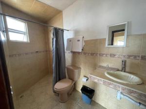 a bathroom with a toilet and a sink at Hotel Los Arcos in Tlalpujahua de Rayón