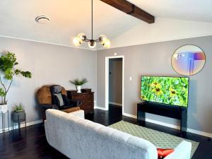 a living room with a couch and a flat screen tv at MODERN LUX 3BR HOME - King Bed - 10 mins to FT HOOD - Fenced yard - Pets ok- Family friendly -LONG or SHORT TERM in Copperas Cove