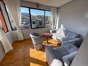 a living room with couches and a large window at Hotel Los Arcos in Tlalpujahua de Rayón