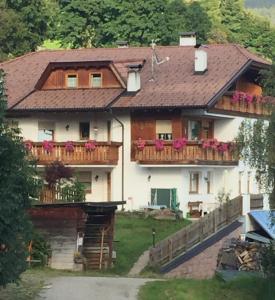 a house with a balcony with flowers on it at Unterweger Hof in Avelengo