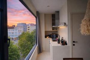 a kitchen with a view of a city at SLEEP INN - Kyoto Suites South Antwerp in Antwerp