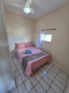 a small bedroom with a pink bed in a room at Apto no centro com 3 quartos in Ilhéus