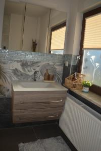 a bathroom with a sink and a mirror at Wolkenfrei am Sonnenhang - Moderne Wohlfühl-Oase mit sonniger Süd-Terrasse in Lebach