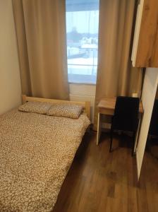 a bedroom with a bed and a desk and a window at Apartament Bieszczady in Lesko