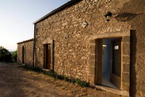 a stone building with two doors on the side at Il Grillo Holiday House in Chiaramonte Gulfi