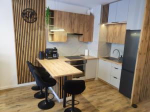 a kitchen with a wooden table and black chairs at Apartament Bieszczady in Lesko