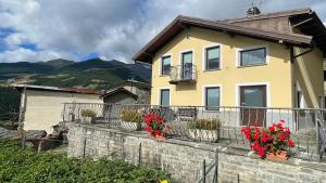 a yellow house with red flowers on a fence at La Ville CIR00002 in Allein