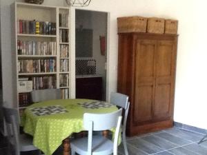 a dining room with a green table and chairs and a door at Studio en pleine nature in Choranche