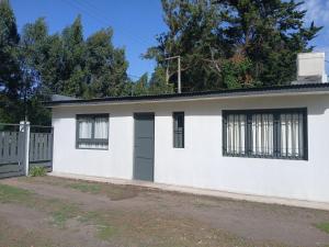 ein weißes Haus mit schwarzer Tür und schwarzen Fenstern in der Unterkunft La isabela in Mar del Plata